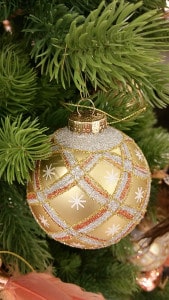 Goldene Weihnachtskugel am Tannenbaum mit schönen Verzierungen.