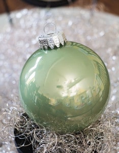 Weihnachtskugel in der Farbe Pastell Grün auf silbernen Engelshaar.